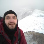 Man on top of Snowdon mountain while it is covered in snow